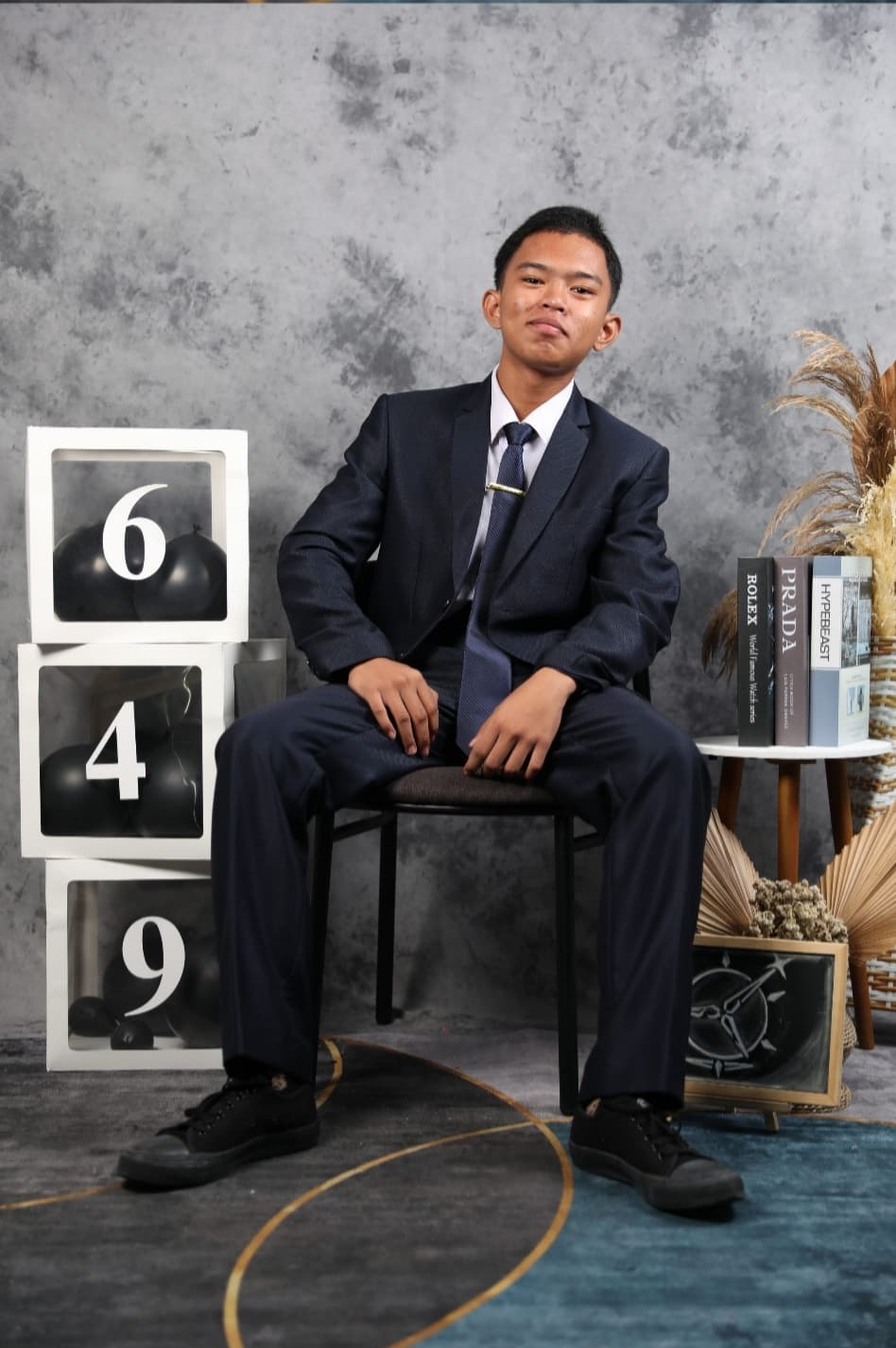 Ridho memakai jas, duduk di studio foto